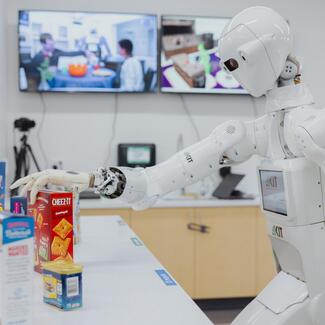 ARMAR, a robot visiting from the Karlsruhe Institute of Technology, helped deliver food in the Robotics Center kitchen. Andrew Brodhead photo.