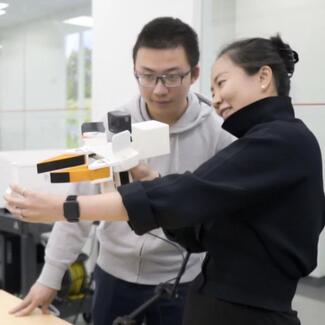 Photo credit Huy Ha. Professor Shuran Song and student using the Universal Manipulation Interface (UMI).